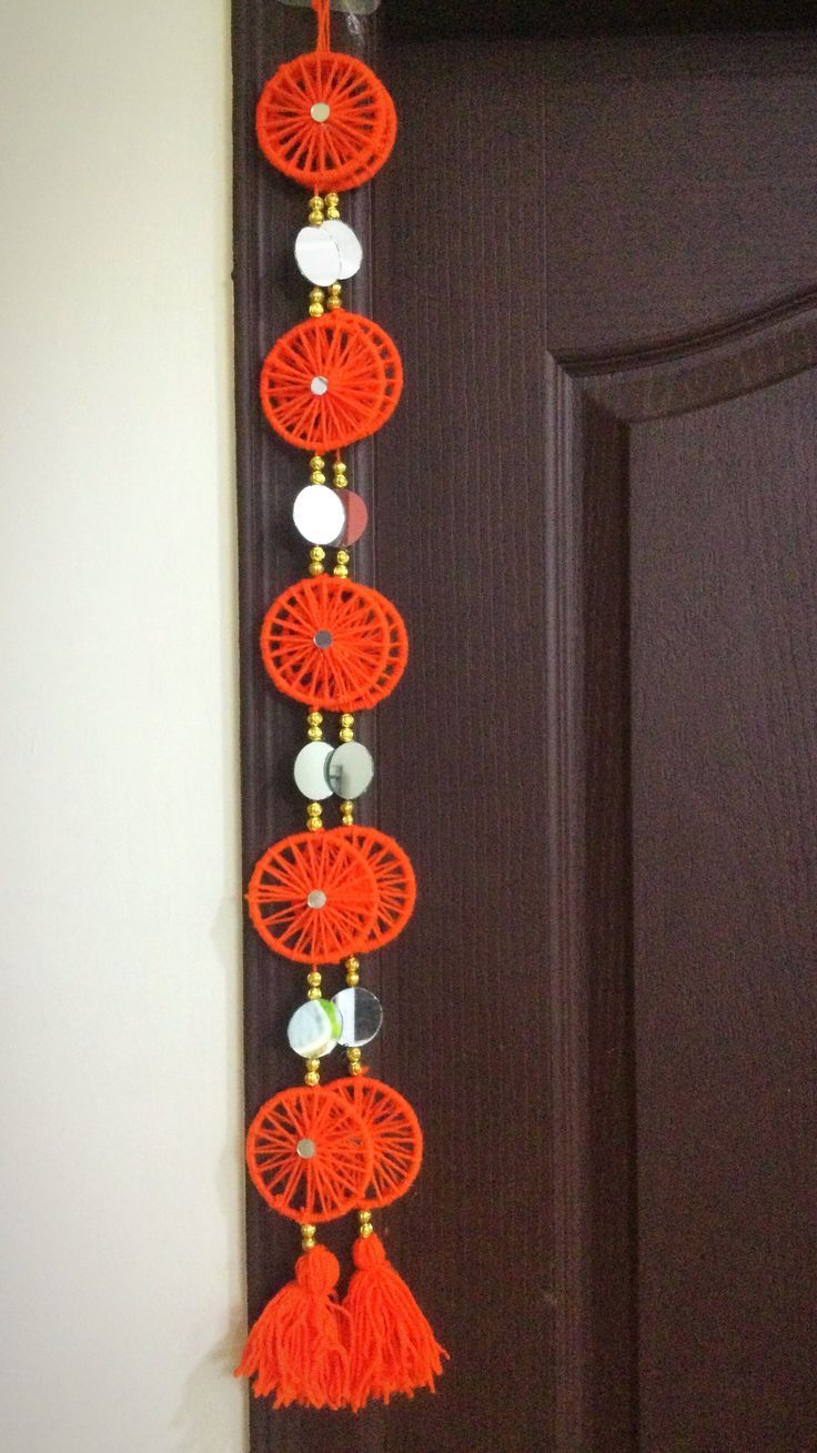 an orange string hanging from the side of a door with beads and tassels