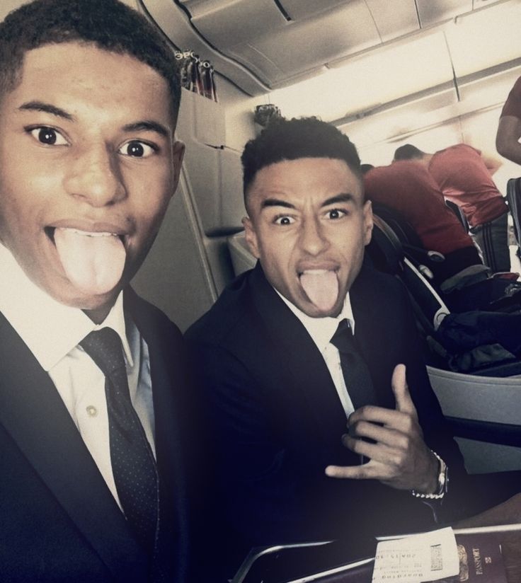 two men in suits and ties making funny faces on an airplane with their mouths open