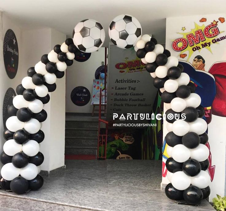 some black and white balloons are in the shape of soccer balls