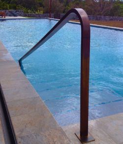 an empty swimming pool next to a metal railing