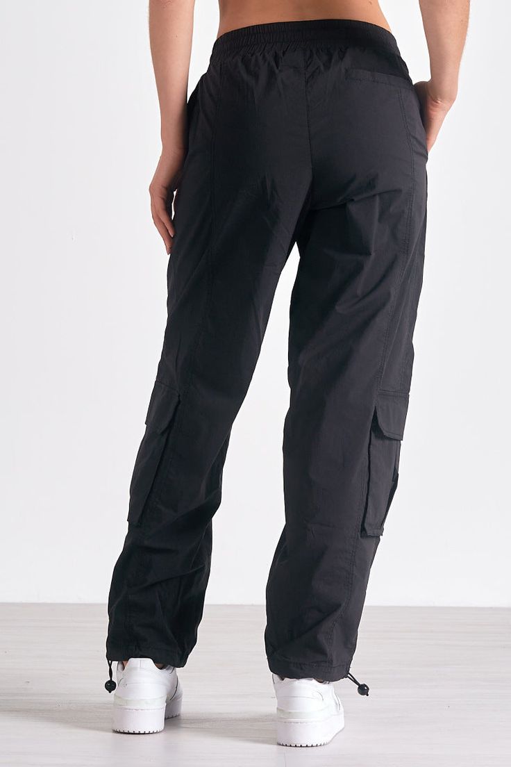 Channel utility-chic in Krystian pants. These cargo-style trousers feature large pockets and a parachute silhouette, with adjustable ankle drawstrings for versatile styling. Parachute Silhouette, Denim Dress Fall, Jumpsuit Coverup, Fall Bottoms, Jumpsuit Fall, Pants With Elastic Waist, Style Trousers, Cardigan Sweater Dress, Black Cargo Pants