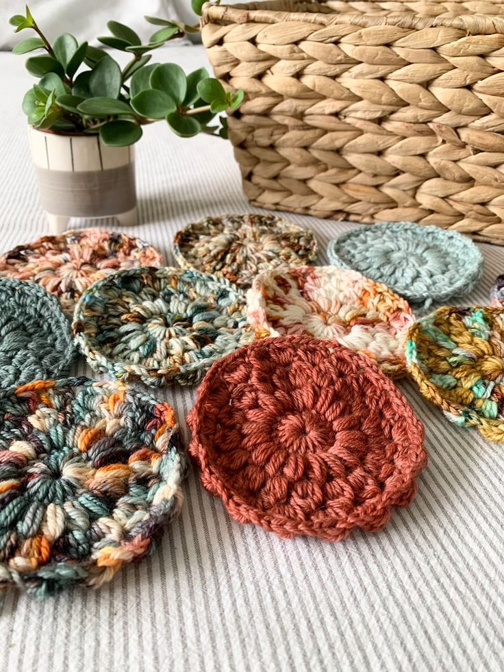 several crocheted coasters sitting on top of a table next to a basket