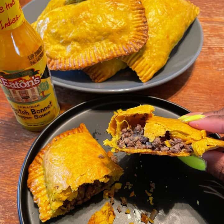 a person is taking a bite out of a beef and cheese empana pie