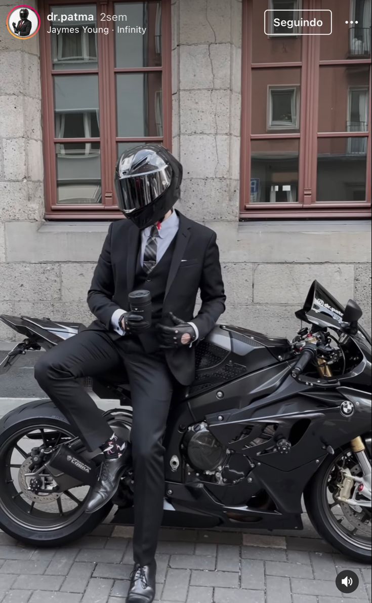 a man in a suit and helmet sitting on a motorcycle