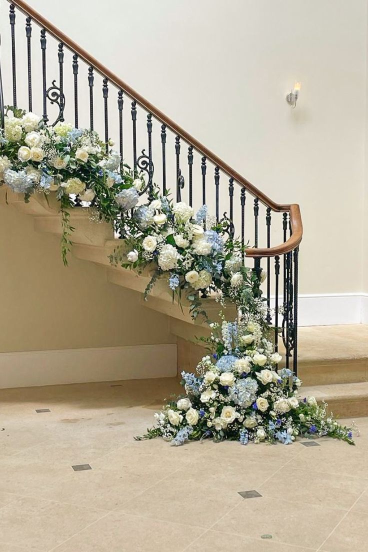 a bunch of flowers sitting on the ground next to a bannister and stairs