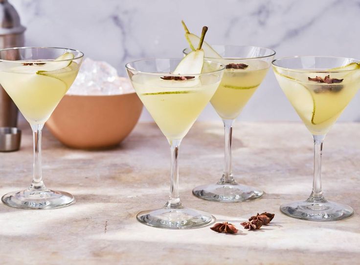 three glasses filled with different types of drinks on top of a marble table next to an egg