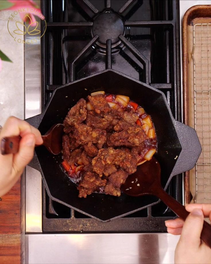 someone is cooking food in a skillet on the stove top with a spatula