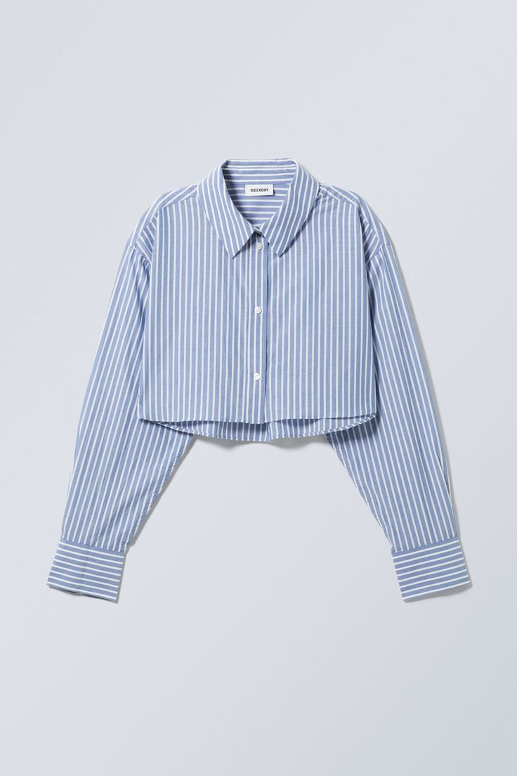 A cropped buttoned shirt made from crisp and soft chambray. It has a pointed collar, a box pleat, buttoned cuffs, and a straight hemline. Cropped Shirt Women, Cropped Button Up, Camisa Crop Top Outfit, Crop Shirt Outfits, Cropped Button Up Shirt Outfit, Cropped Dress Shirt, Crop Button Up Shirt, Cropped Shirt Outfit, Cropped Collared Shirt