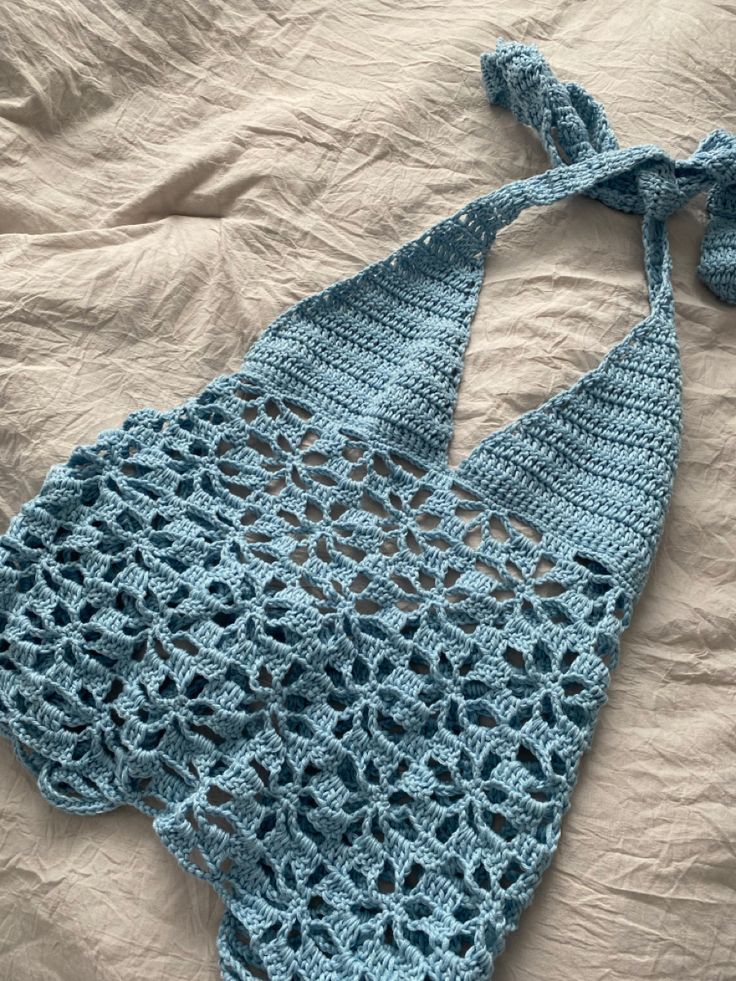 a crocheted blue bikinisuit laying on top of a bed