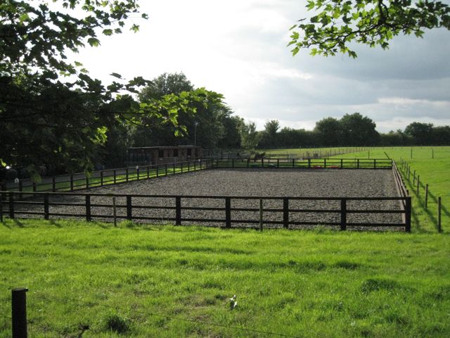 an empty horse paddock in the middle of a field