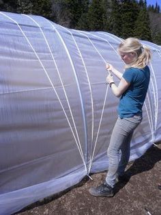 two women are working on an inflatable structure with wires attached to the sides