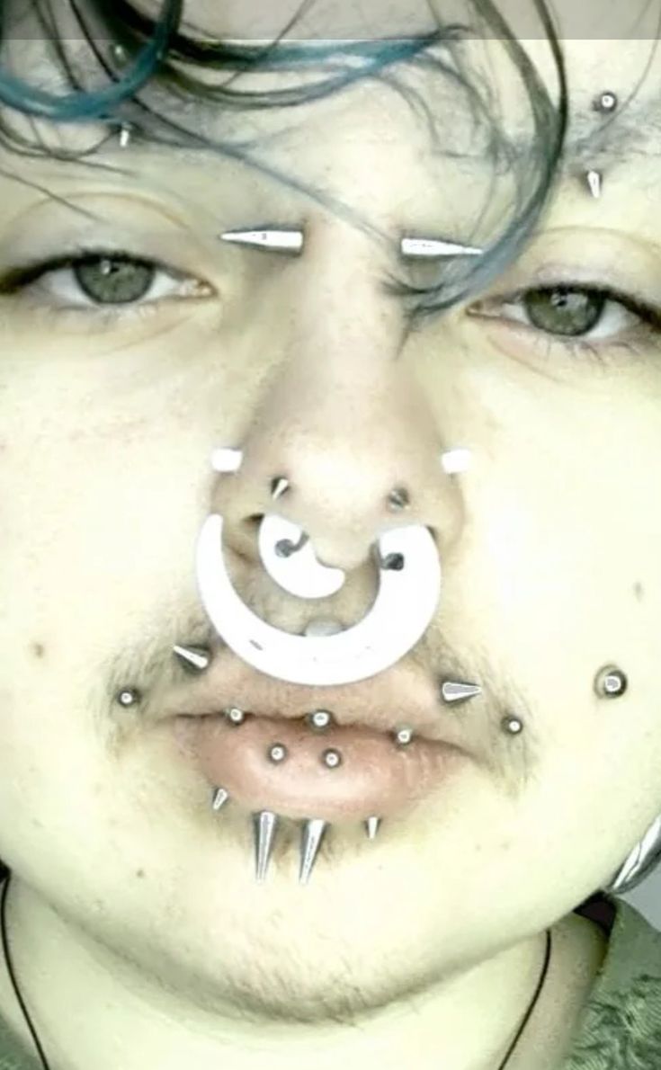 a man with piercings on his face and nose