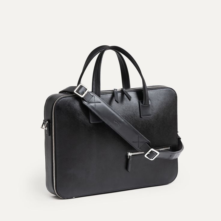 Ce briefcase Paolo propose un design très épuré. Aucune poche extérieure ne vient perturber le volume du sac en dehors de notre poche signature sur l’avant : une poche zippée permettant de venir y glisser son passeport. Un sac très compact qui vous surprendra par ses capacités de rangement ! Côté matière, ce sac est réalisé dans notre cuir Saffiano, un cuir pleine fleur de grande qualité, à l’aspect légèrement satiné et qui ne s’altèrera pas avec le temps. Les fermetures à glissières sont réalisées par YKK, un des plus grand spécialistes au monde, et nos mousquetons réalisés en laiton pour garantir une résistance maximale. Le porte-documents Paolo est proposé avec sa sangle en cuir pour un porté épaule, et vous sera livré dans un pochon de protection.