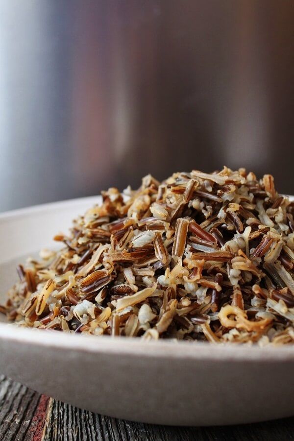 a white bowl filled with nuts on top of a wooden table