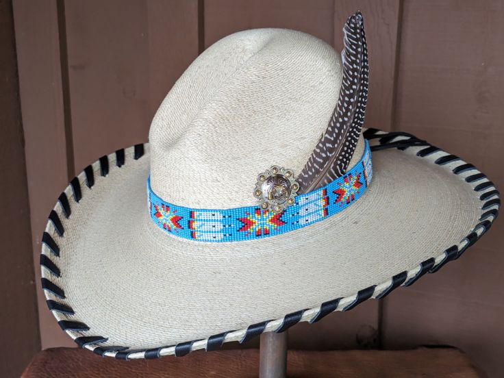 The Renegade Gus Palm Hat has a 4" brim and 5 1/2" crown. Super comfortable with a sweat band on the inside. Hand laced in black leather lace. Beautiful blue beaded hatband is secured on the hat and the back of the band has a deer antler bead. Accented with a Concho and Guinea feathers. Note: Hats are made to order. Please allow up to 4 weeks for your hat to ship Country Style Hat With Flat Crown For Country Events, Western Style Adjustable Panama Hat For Kentucky Derby, Adjustable Flat Crown Hats For Kentucky Derby, Adjustable Top Hat With Flat Crown For Ranch, Adjustable Country Style Top Hat For Country Events, Western Adjustable Costume Hats And Headpieces For Country Events, Western High Crown Costume Hat For Rodeo, Adjustable Short Brim Top Hat For Rodeo, Custom High Crown Hats For Festivals