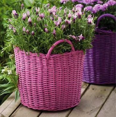 three baskets with flowers in them sitting on a wooden table outside, one is purple and the other is pink