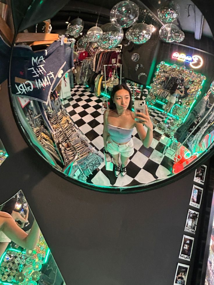 a woman taking a selfie in a mirror at a jewelry store with green and white checkered flooring