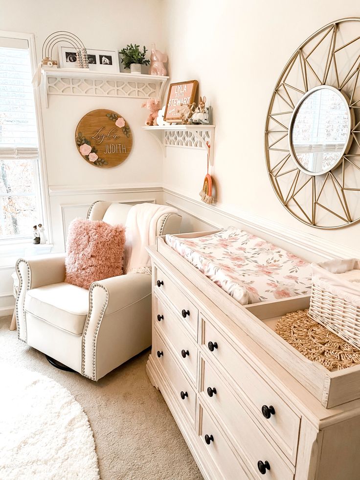 a baby's room with a crib, dresser and mirror on the wall