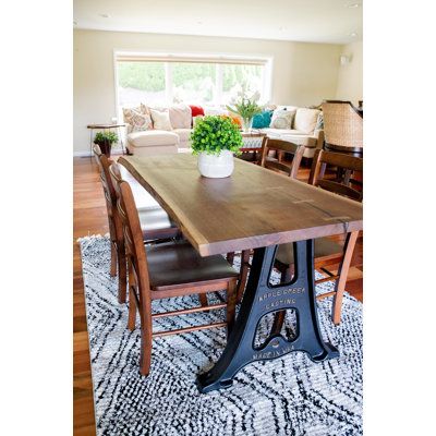 a dining room table with chairs and a potted plant on top of the table