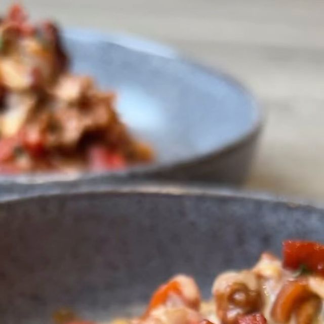 two bowls filled with food on top of a wooden table