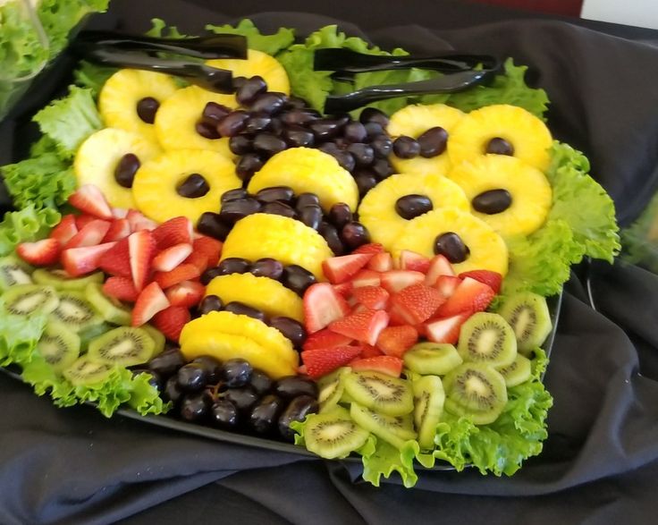 a plate with fruit and vegetables in the shape of smiley faces