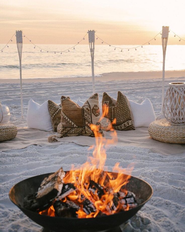 a fire pit sitting on top of a sandy beach