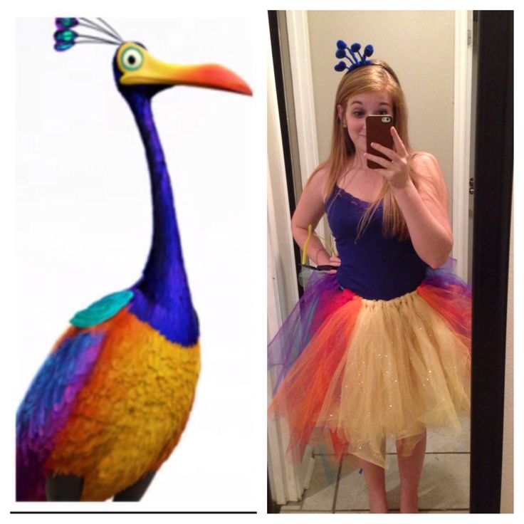 a woman taking a selfie in front of a mirror with a peacock costume on