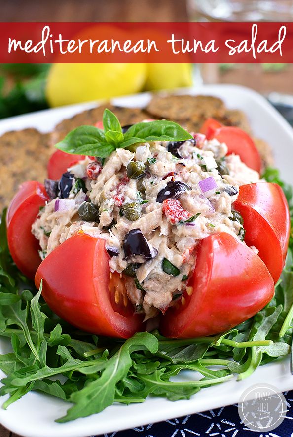 a white plate topped with tomatoes and tuna salad