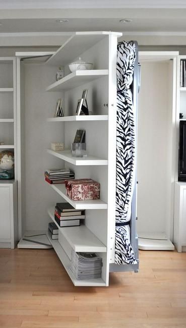 a room with white shelving and bookshelves