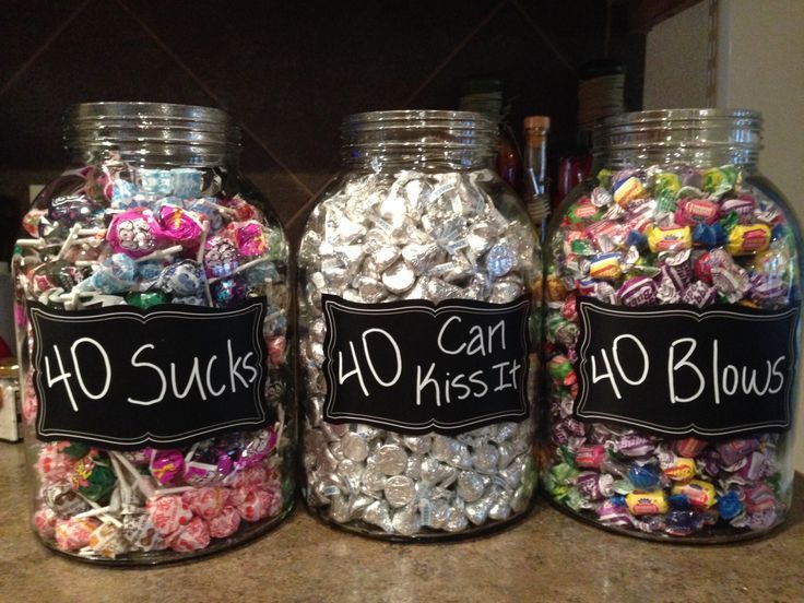 three glass jars filled with candy sitting on top of a counter