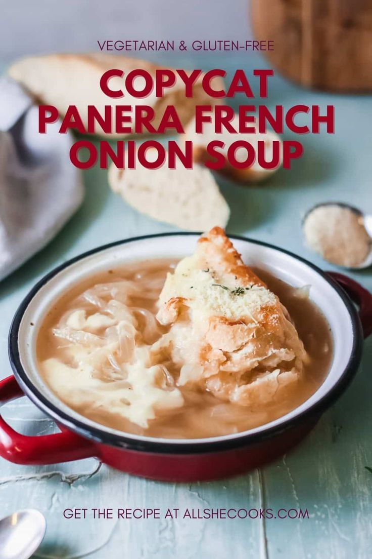 a red bowl filled with soup on top of a blue table next to bread and spoons