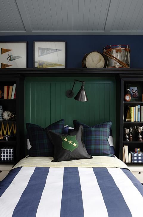 there is a bed with blue and white sheets in the room that has bookshelves