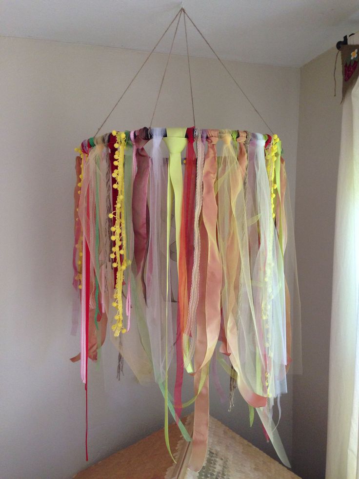 some colorful streamers hanging from a ceiling in a room with white walls and curtains