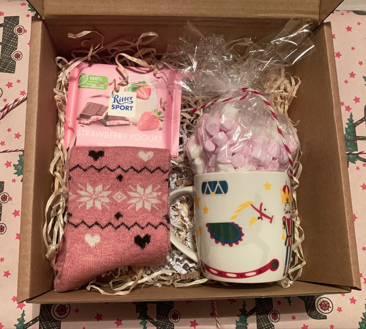 a box with two coffee mugs, socks and candy