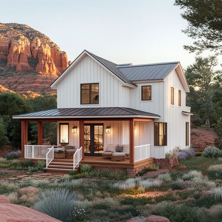 a white house with a porch in the mountains