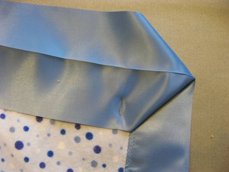 a blue and white polka dot tie laying on top of a piece of cloth with a hole in the middle