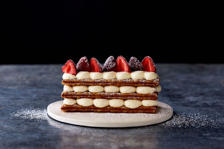 a piece of cake sitting on top of a counter next to strawberries and cream