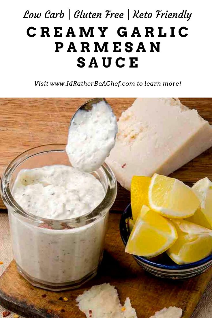 creamy garlic parmesan sauce in a jar with lemons on the side