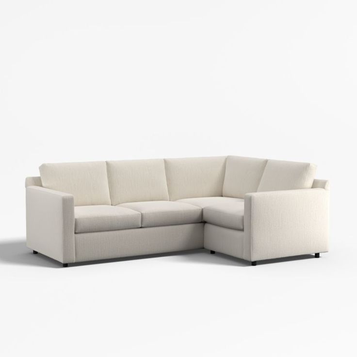 a white sectional couch sitting on top of a white floor