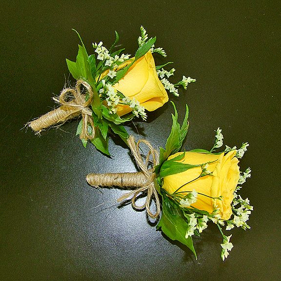 three yellow roses tied together with twine and some baby's breathflowers