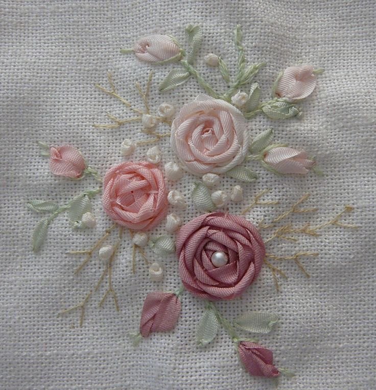 some pink flowers and pearls on a white cloth