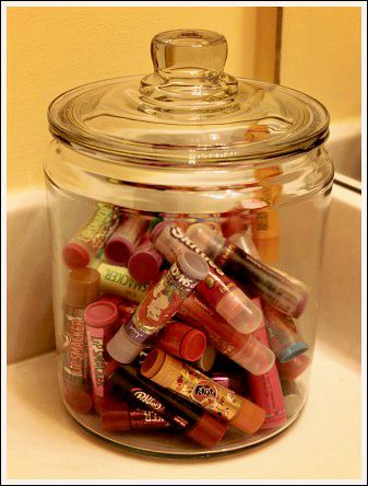 a glass jar filled with lots of different types of lipstick