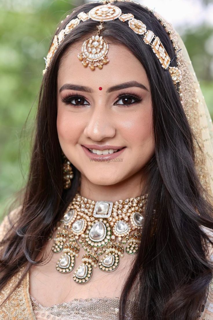 a woman wearing a bridal outfit and jewelry