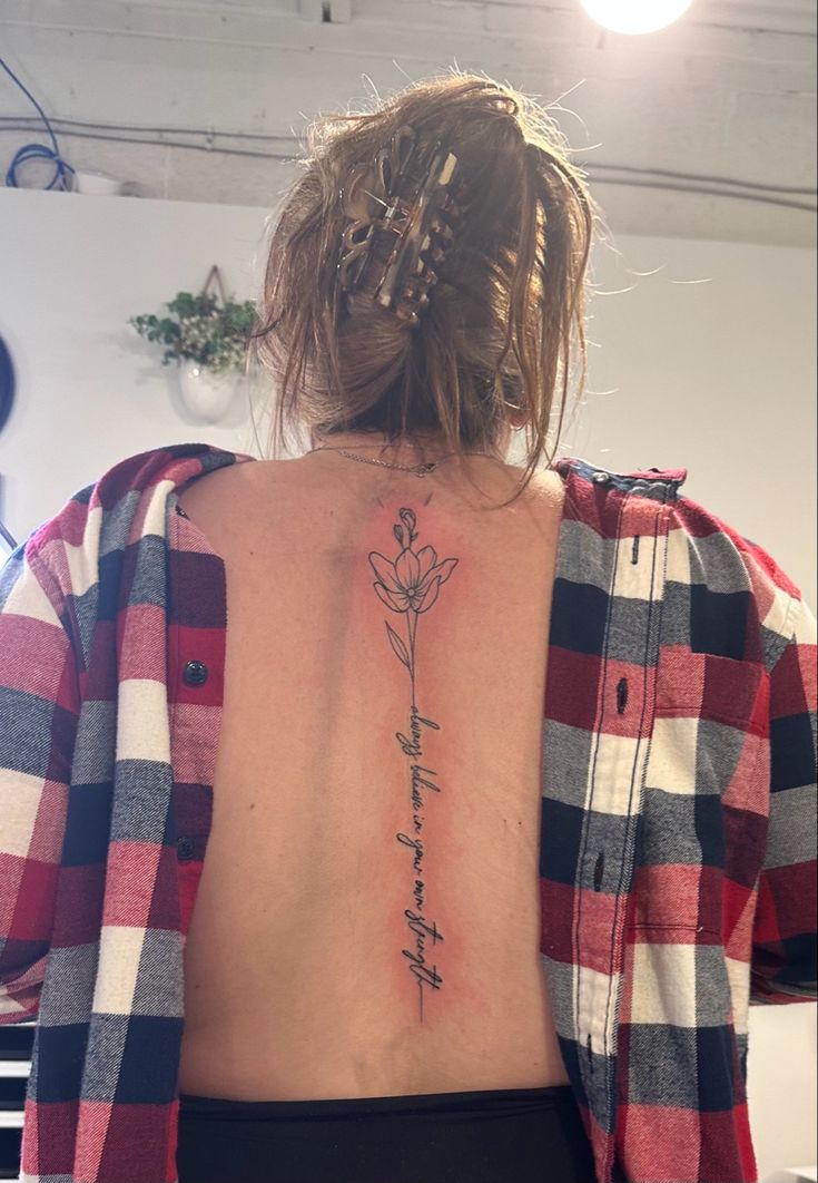 a woman with a flower tattoo on her back