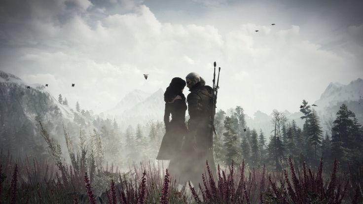 two people standing in the middle of a field with trees and mountains in the background