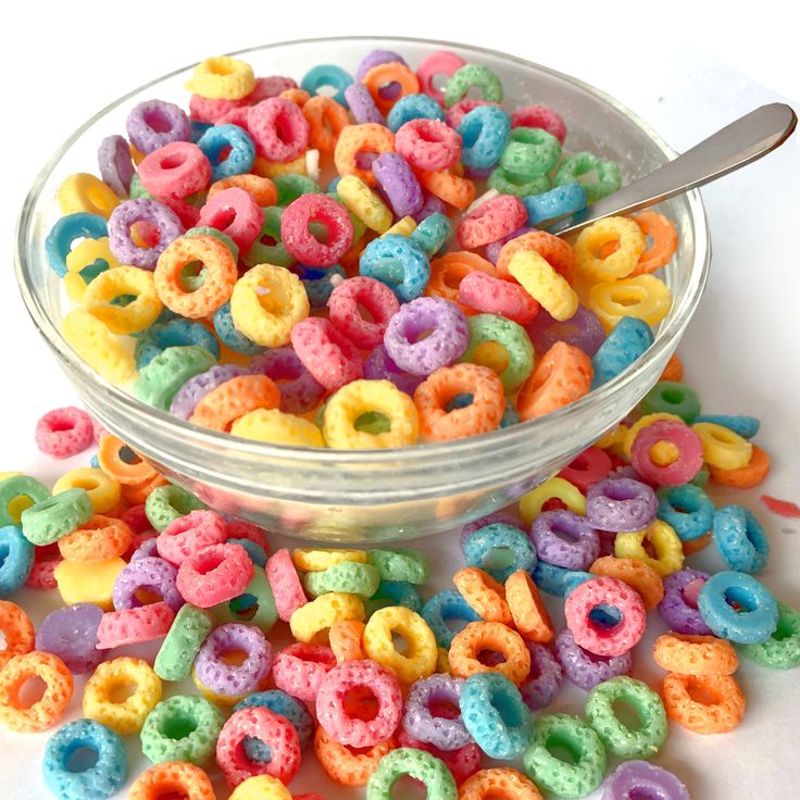 a bowl filled with colorful cereal sitting on top of a table