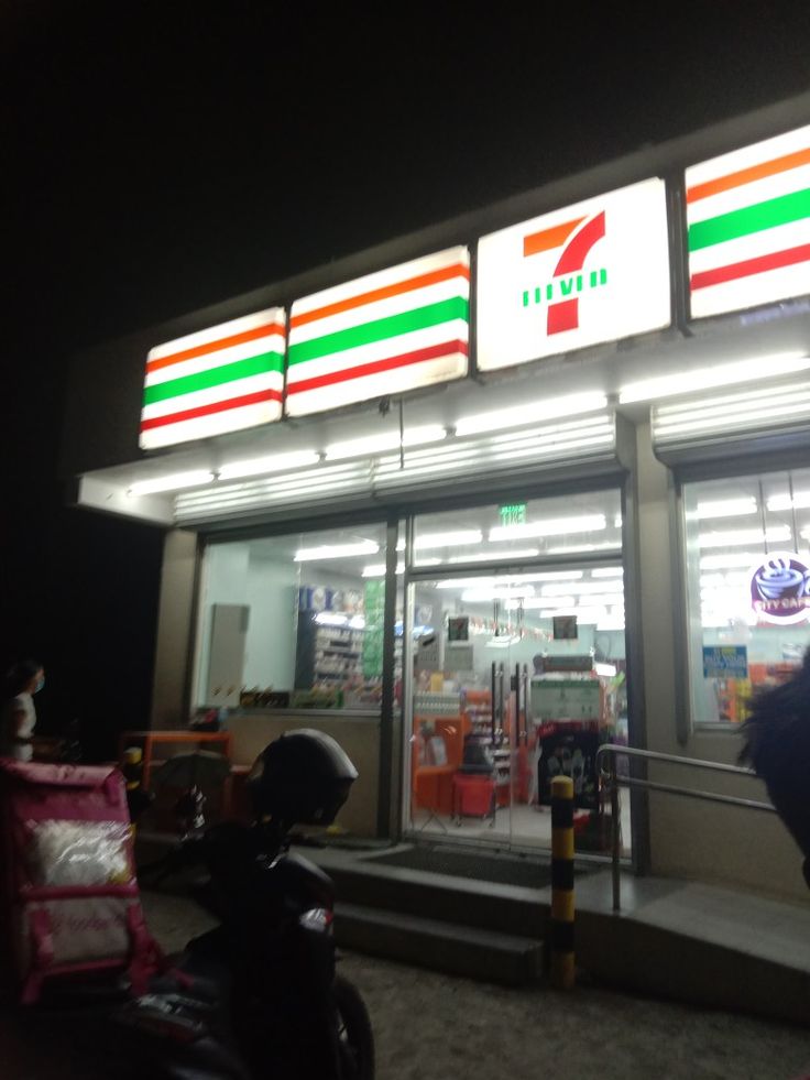 a motorcycle parked in front of a pizza hut with the lights on at night time