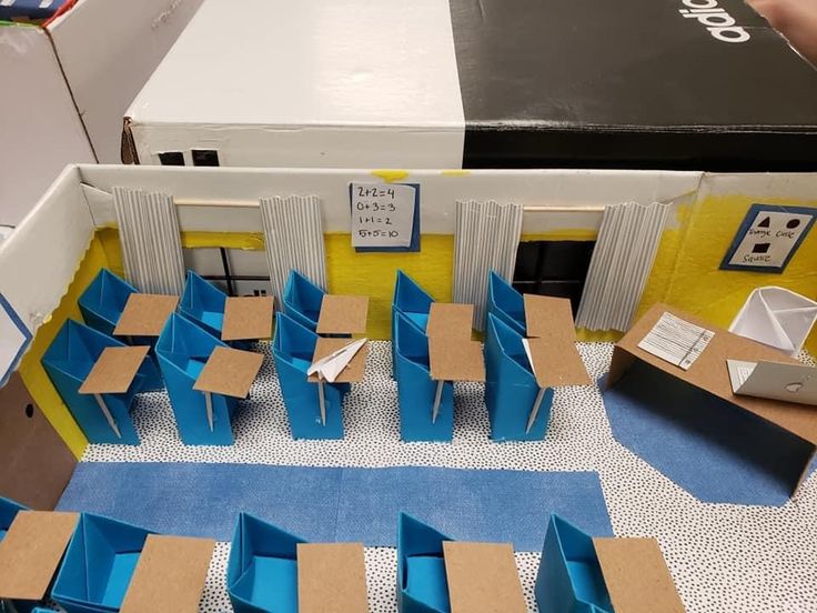 an open room with blue chairs and cardboard boxes on the floor in front of it