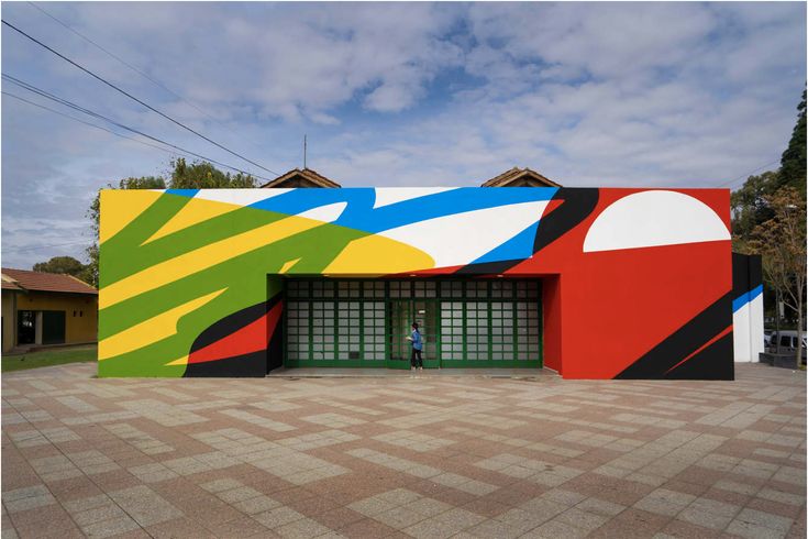 a colorful building with an open door on the front and two people standing outside it