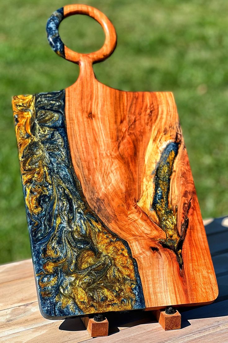 a wooden cutting board sitting on top of a table next to a piece of wood